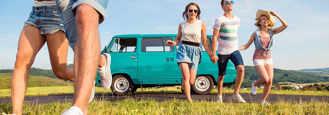 Running teenage couples in love outside against blue sky